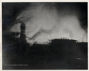 Smoke emanating from burning mill at night.
