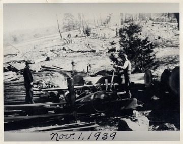 Two men using lumber machinery next to a timbered hillside.  Pendleton Co.