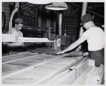 Two men cutting wood.  L to R  1. Arthur White  2. Marvin Moss