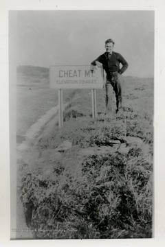 Paul James leaning on Cheat Mountian elevation sign.