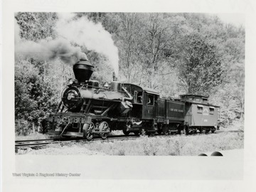 Cass Scenic Railroad.  Locomotive train engine with caboose on train tracks.  