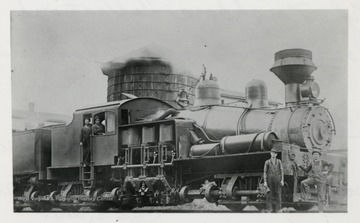 Side view of Shay #8 train engine.  Two crew members in the front, two crew members in the train engine.  