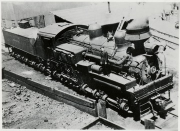 View looking down on Shay train engine.  Man standing on engine.  