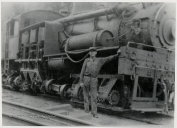 Man leaning against a train engine.