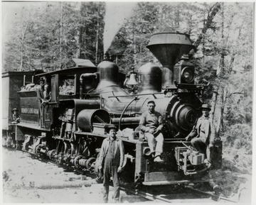 3/4 front view of Shay train engine No. 1.  Two men sitting on the front of the engine.  One man standing beside the engine.  Two men in the cab of the engine.
