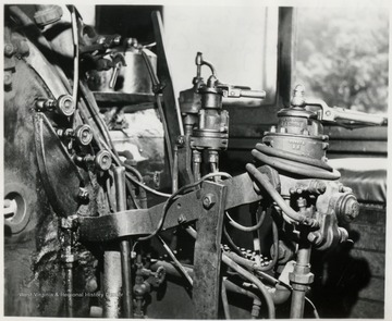 'Controls inside the cab of a Shay look like this.  Shown are train and engine brake controls, reverse bar, water injector, and throttle and water-gauge cocks.  Visitors are welcome to visit the cab between 'runs' and they do!'