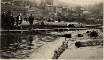 Men working with logs in the Ranwood Log Pond.