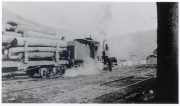 Train engine hauling logs.