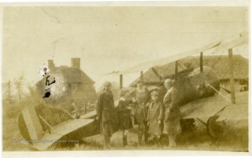 Group of friends of Louis Bennett, Jr. stand in front of an airplane.  Names listed on back are Verity, Mordaunt, Lettice Aceland, Ottilie, and Ethel Mills.  Portrait of Lt. Louis Bennett, Jr., R.F.C.  This photograph, as well as others (numbers 001378, 001379, and 001380) are referenced in a letter from Mrs. Ethel Mills to Mrs. Louis Bennett, Sr. The text of the letter is as follows: August 20, 1919 Drokes, Beaulieu, Hants My Dear Mrs. Bennett, I just want to reach across the channel, and take your hand and hold it, in a great understanding silence! To begin with, you could not have had my address if your dear boy had not given it!  I hope you will be coming to England [and] will come to us for a few days.  And get to know his old surroundings here -- where he lived [and] bunked.  I remember I was at work building a pig stye! -- when suddenly he appeared flying round [and] round my house and suddenly he made the most beautiful desent [sic] and stood before us, with his handsome face glowing, 'I’ve come to say good bye' -- he could only stay for ½ an hour -- and we mutually photographed each other -- then he was gone, saying 'I’ll send back my photo for you all to sign.'  He had no sooner gone, than I grieved I hadn’t asked him for your address, so as to send you any of ours that might be good, as I knew how you’d love to have as many snapshots as possible, but hoped I’d soon hear from him.  Well at last I did write -- the photo I had to wait sometime to get a signature -- [and] something made me write to him without returning him his [and] ours --  fearing he had moved from his last address -- so I said do tell me if this reaches you before I send the precious photos.'  And I waited, [and] as time passed, I feared he had gone to join with those other warriors!  Then came the trying to find you, [and] send you these precious snapshots. [and] so when I saw your envelope, before I opened it, or had even turned it round, I knew what its contents must be [and] I just felt greatful that evidently he looked upon us as friends, [and] so had given you my name and address.  You will let me see you should you come to England won’t you -- [and] if possible you will come down to Bealieu [and] be with us for a little while. I will not write more tonight -- but with true love [and] the deepest sympathy to Mr. Bennett and yourself. Yours affectionately Ethel Mills You will want his letter too.  You will see the fine way he agitated to get to France and to be fighting!