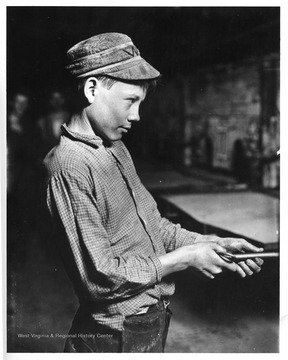 Candid portrait of a carrying-in boy working at the lehr in a glass factory in Grafton, West Virginia. Credit National Archives 102-LH-164.