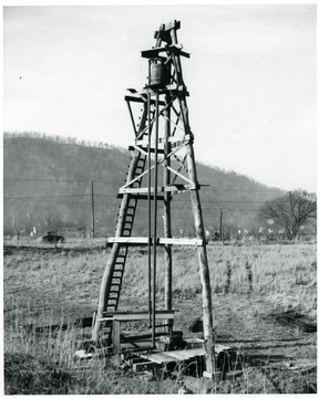Salt well.  Two men are standing in the distance next to a telephone pole.