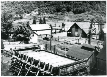 An aerial view of the factory with the salt water reserve tank in the foreground and other various buildings surrounding it.