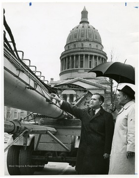 Barron touches the U.S.S. West Virginia mass. The capitol building stands in the background. 