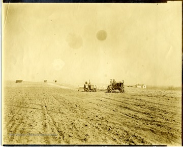 Men spreading lime on a large field with two tractors at Arthurdale.