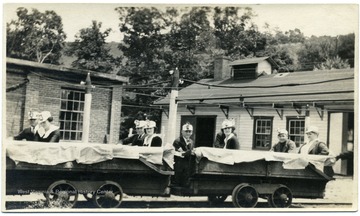 Group of people in coal cars outside of the Hutchinson Family Mine near Fairmont, W. Va. 