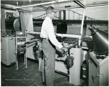 The pilothouse of the Humphrey towboat with a man at the controls.