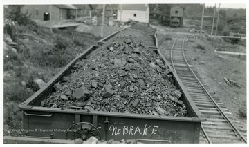 View of three coal cars. First coal car has 'No BRAKE' written on it.