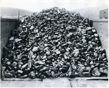 Caption on back reads, 'The most popular size smokeless coal marketed today is egg size and White Oak is proud of its egg coal. Neither too large, nor too small; perfectly screened and without a single impurity are reasons for the popularity of this wonderful domestic fuel. Note the even size of this egg coal as it is passing over the loading boom into the railroad car. Treated for dust if desired.'