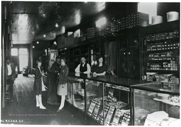 A Company store with two people behind the counter with four people standing on the other side.