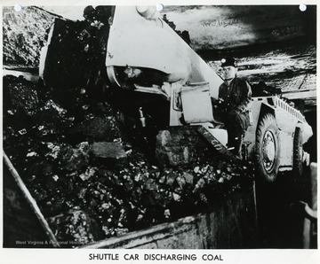 A miner empties his shuttle car.