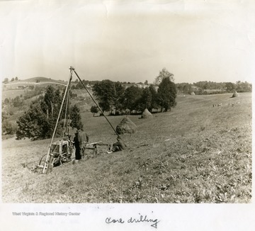 Men work with core drilling equipment on a hillside.