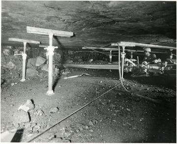 Man cutting coal in Consol. Coal Co. Mine in Kentucky. Note the roof supports using jacks.