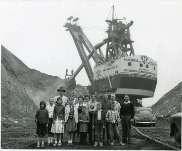 Group portrait of children standing in front of the large shovel 'The Mountaineer'.