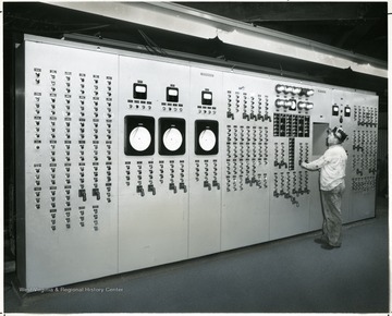 Mine worker examining main control panel, Williams, May 15, 1953.
