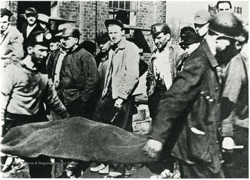 Miners carry the body of a miner killed in a gas explosion at Exeter, Pennsylvania through a crowd of miners and onlookers.