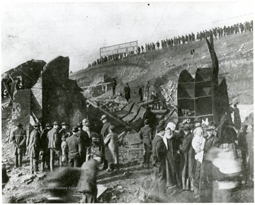 'Shows the scene about the mouth of No. 8 Monongah Mine explosion, where the fan house and other buildings were completely demolished by the force of the explosion and where Engineer Byce was killed. The photograph was taken just as bodies of the victims were being brought out of the mine.'