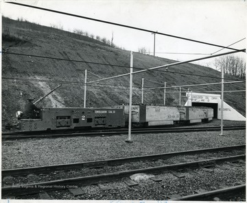 Miner operates a train of coal cars loaded with raw coal departing from Consol Mine No. 32.