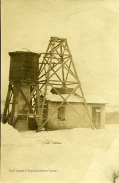 Water tank and wooden framework over a building in winter.
