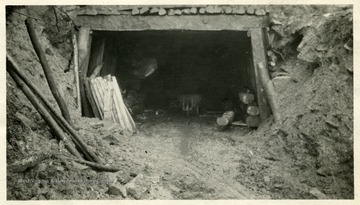 A mine entrance full of logs and lumber.