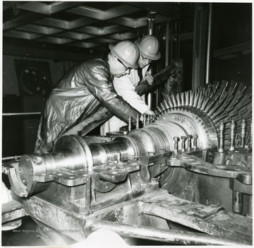 J.P. McGee, Acting Research Director, and Jack Smith, in Charge of the Gas Turbine Development Project discuss proper positioning of the turbine rotor in its casing.