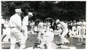 Men in white uniform work on a practice victim.