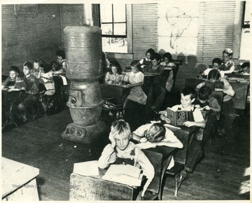 Miner's children in school. Large stove in center of room.