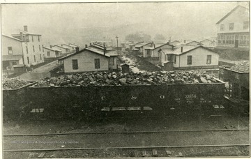 Filled Chesapeake and Ohio coal car in front of a group of houses at Tams, W. Va.Picture includes: Betty Jean Seals, Robert Church, Doris Williams, Marlene Dews, Leroy Messingbery, Josephine or Ernestine Hill, Whitney Hairston, Wilfred Younger, and Charlene Jennings.