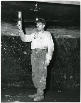 Miner tests for gas in mine.