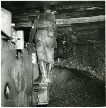 A very large cutting machine being operated by a miner. 'Credit must be given to William Vandivert, Not to be reproduced without written liscense.