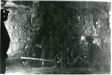 A miner works on a piece of machinery on the interior of the mine. John Williams, Coal Life Project.