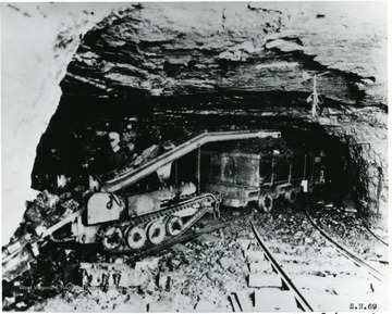 Miner working with a loading machine. 'Compliments of Joy Manufacturing Co.'