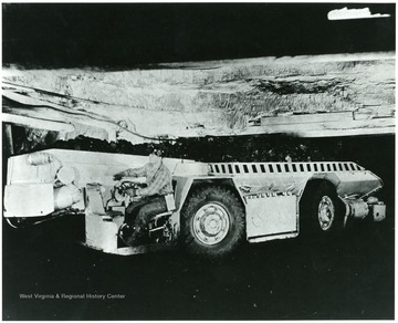 Miner driving a shuttle car. 'Shuttle car, fully loaded, rumbles around a curve on its way to the loading terminal where it will unload into mine cars. Such mechanized equipment has a unit cost of about $20,000. Mine No. 32, Consolidation Coal Co., Owings, W. Va.'
