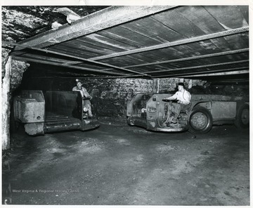 'Shuttle Cars: Here are pictured loaded and empty shuttle cars sometimes called buggies. Note the noveyor on the bottom of the empty car for unloading the coal at a central loading station, into the mine cars. This equipment is propelled by huge batteries or electric cable and of course requires no track. Track-mounted mechanical loaders load directly into the mine car.'