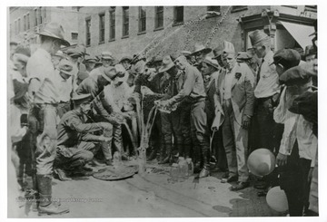 W. Va. State Police pouring out moonshine whiskey on public square in Williamson, W. Va. on the 4th of July, 1921.