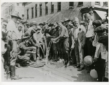 W. Va. State Police pouring out moonshine whiskey on public square in Williamson, W. Va. on the 4th of July, 1921. 