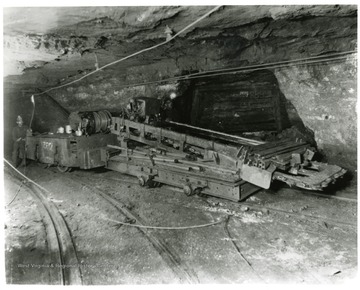 Miner with a large machine in the Pocahontas Mine.