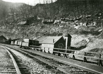 'Matewan looking peaceful.'  Railroad tracks running near a church and other buildings along a hillside.