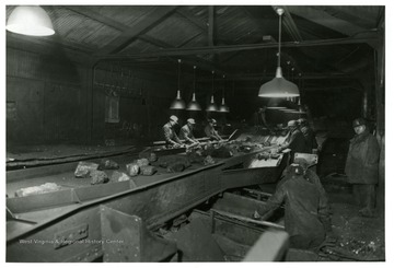 Miners at work after installing mercury vapor lights over picking table at McComas, W. Va., American Coal Co.