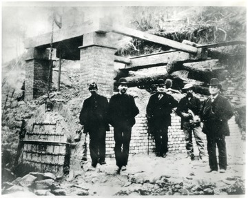 Miners stand beside a patent oven.