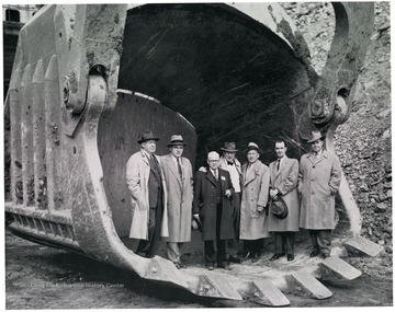 Five business men stand inside of a scoop.